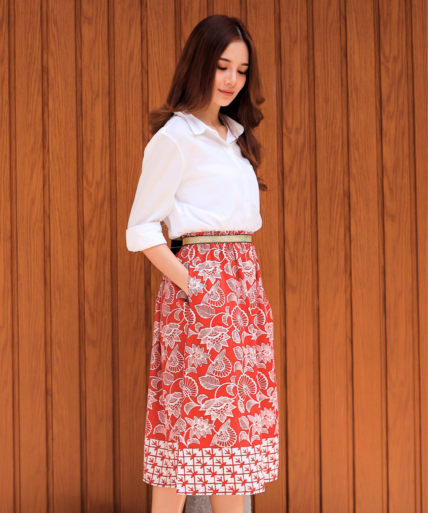 Person wearing pink formal top and skirt.
