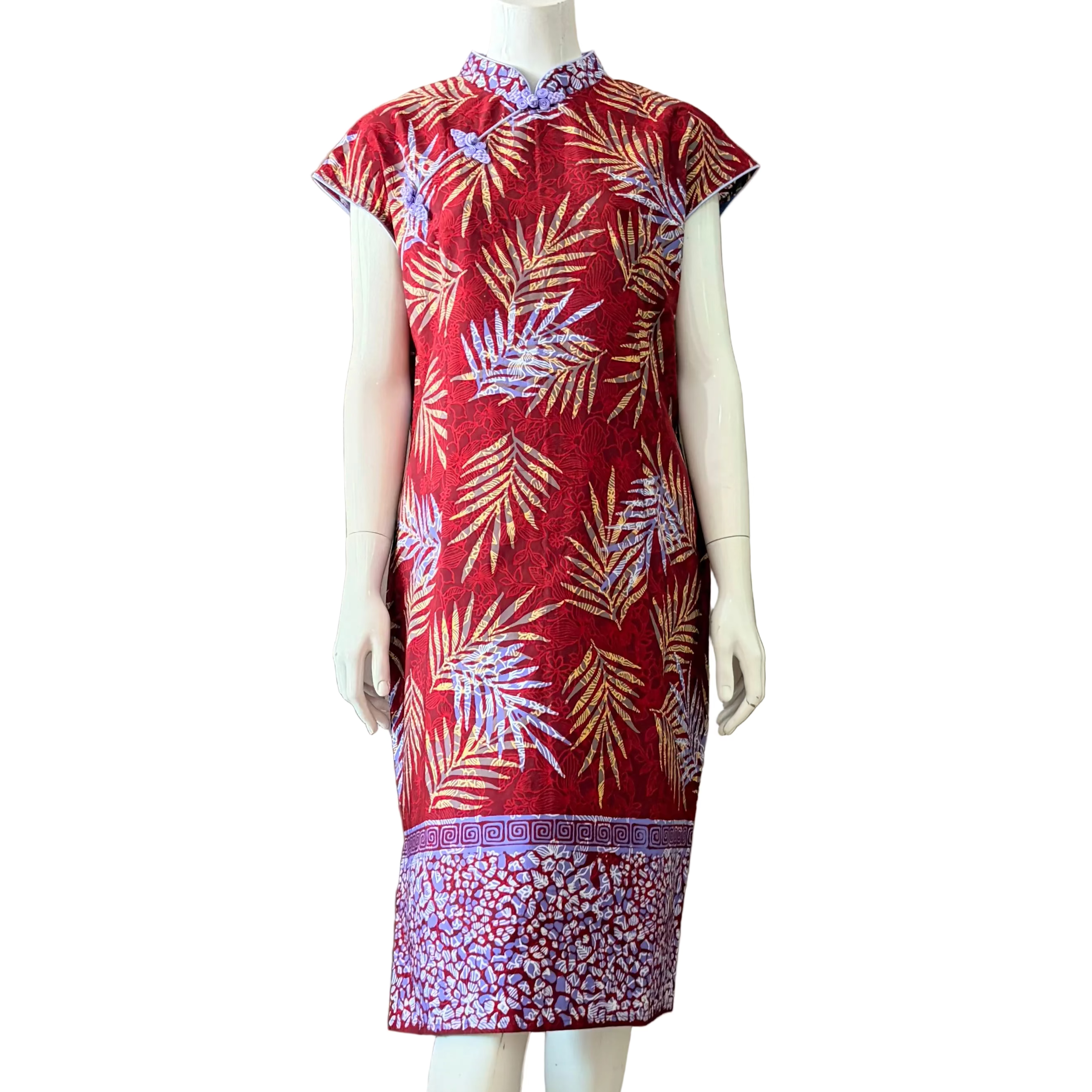 Batik modern print red dress with leaf pattern on a mannequin and border at the bottom and mandarin collar with frog button accents 