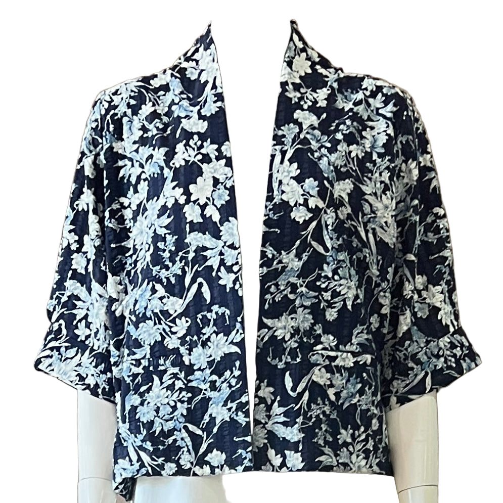 Navy floral patterned blouse on a mannequin against a beige background